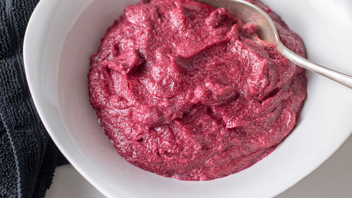 Colorful beet puree in white bowl.
