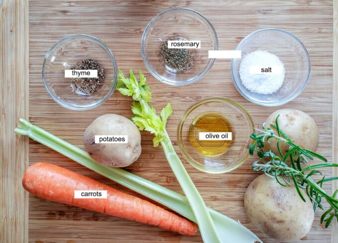 ingredients for pot roast- thyme, rosemary, salt, potatoes, olive oil, potatoes, sage, celery and carrots.