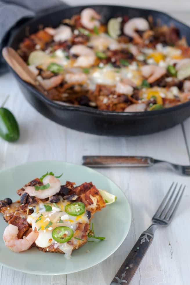 chilaquiles in cast pan with egg topped portion on plate 