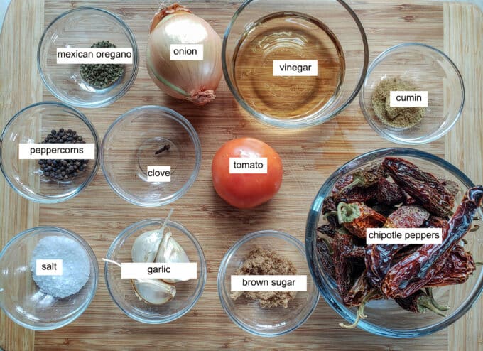 Ingredients for chipotle in adobo- oregano, onion, viegar, cumin, chipotle peppers, tomato, clove, peppercorns, salt, garlic, brown sugar.