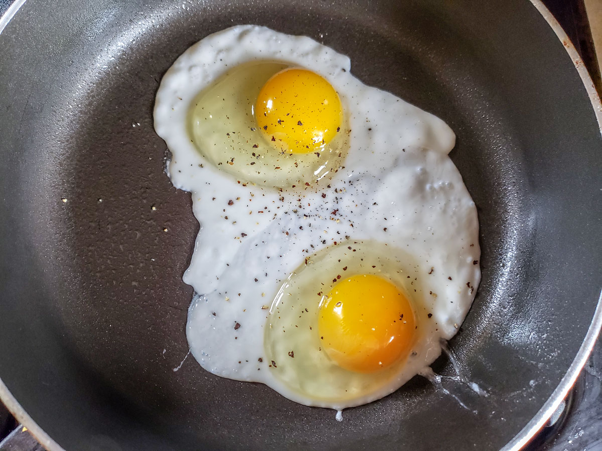 Eggs in frying pan with pepper.
