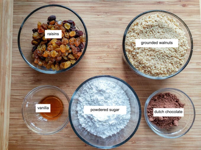 Ingredients for filling on wooden board- raisins, walnuts, vanilla powdered sugar, dutch chocolate.