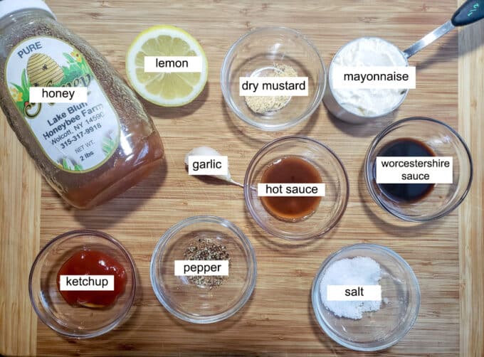 Ingredients for making sauce. Honey, lemon, dry mustard, mayonnaise, garlic, hot sauce, worcestershire sauce, salt, pepper, ketchup