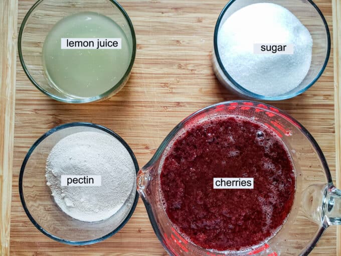 Ingredients for cherry jam- lemon juice, sugar, pectin, cherries with juice.