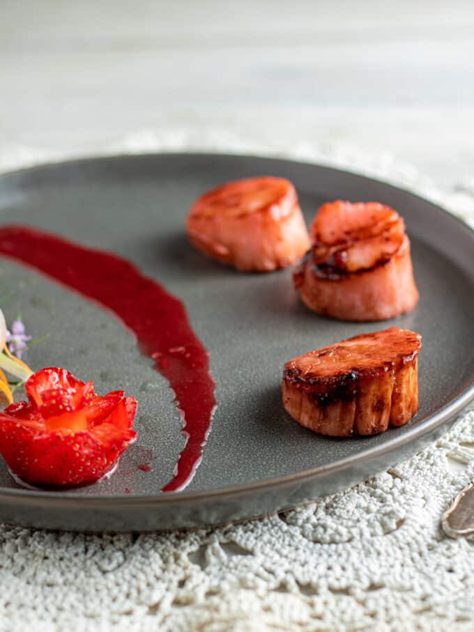 3 strawberry scallops on gray plate.