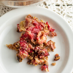 White plate filled with rhubrab crisp with crispy topping.