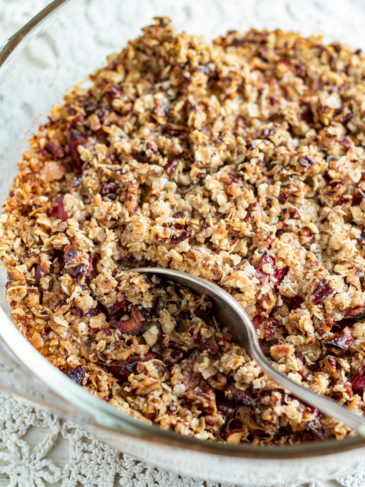 Whole rhubarb crisp dessert with silver spoon.