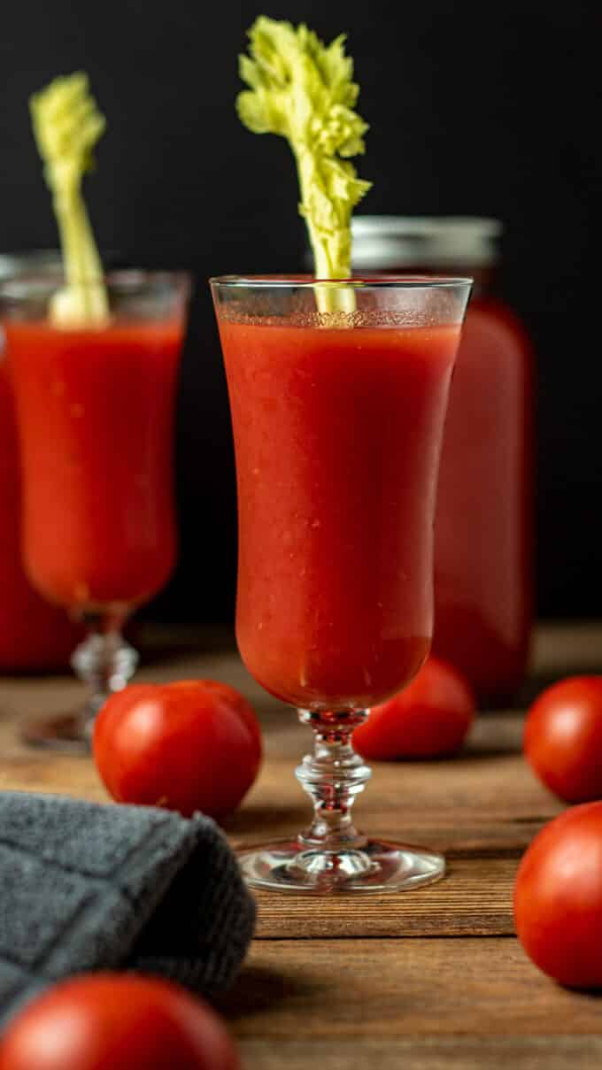Two glasses of tomato juice with celery garnish.