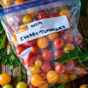 Freezer bags with whole tomatoes ready for freezing.