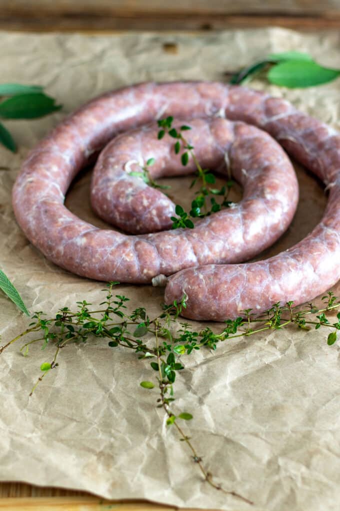 Coil of uncooked sausage of brown paper.