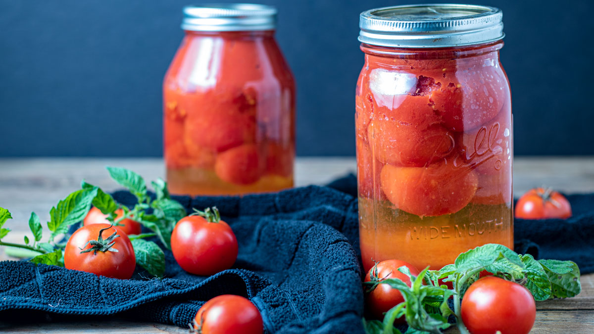 Canned tomatoes on barn wood background.