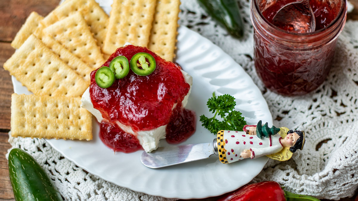 Cranberry pepper jelly covered cream cheese appetizer plate with crackers.