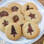 White plate filled with jam filled cookies.