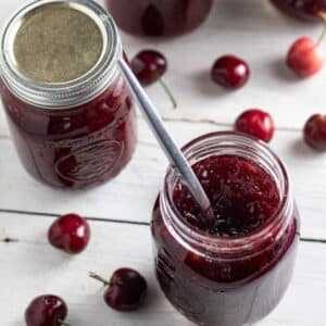Jar of cherry jam with spoon.