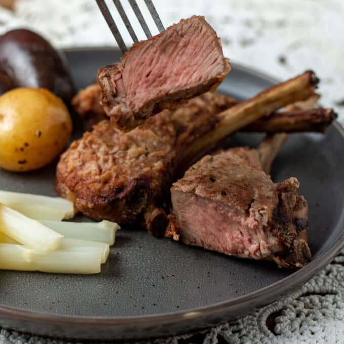 Close up photo of cut lamb chop on fork
