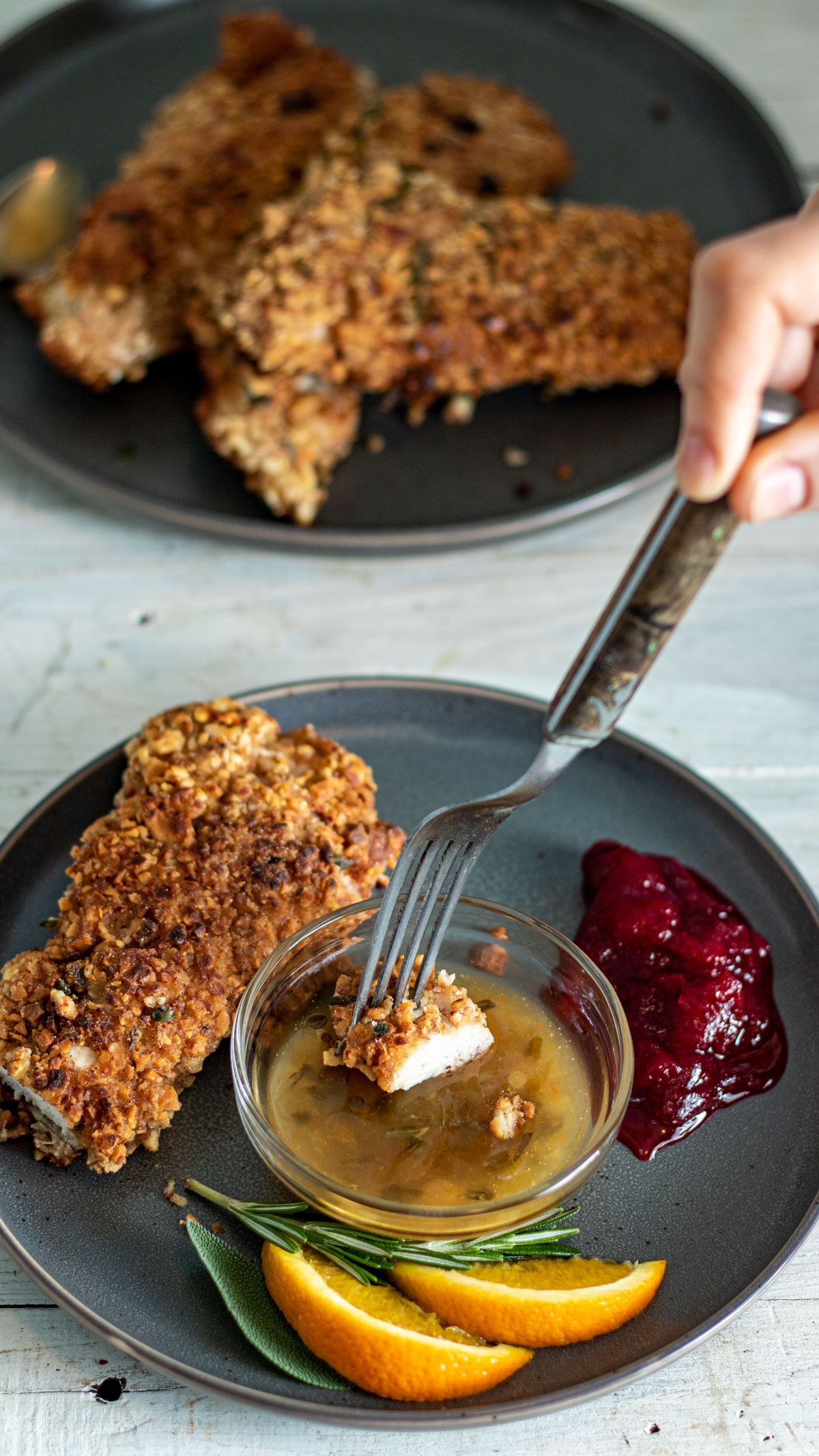 Fork dipping piece of turkey into orange sauce.