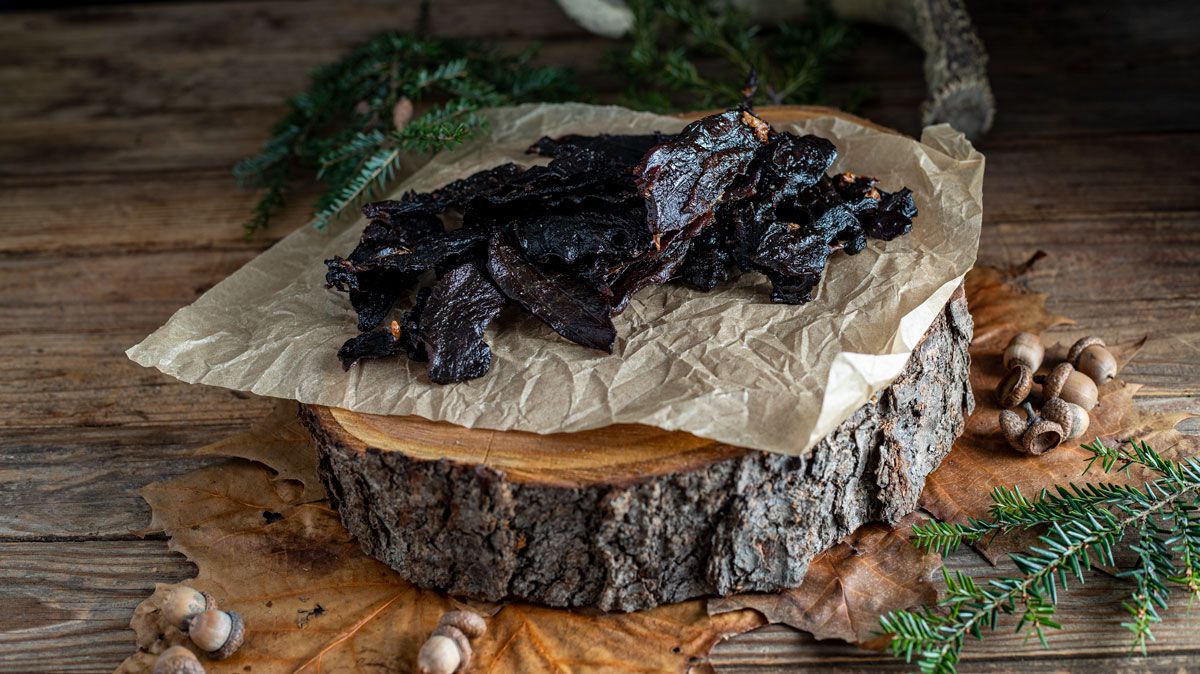 Pile of jerky on tree slab.