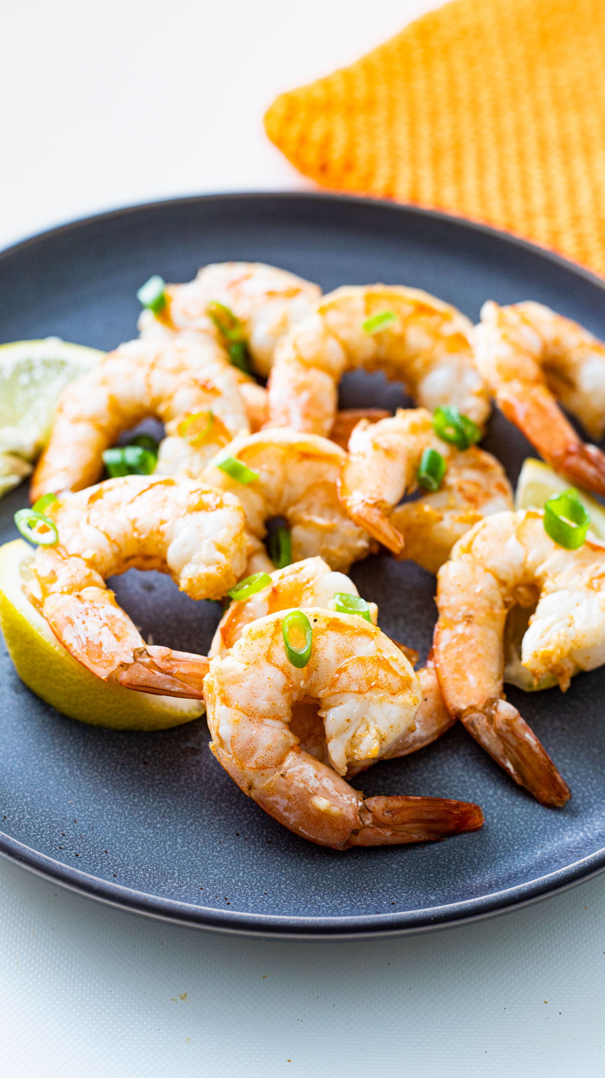 Pile of perfectly cooked shrimp on a gray plate.