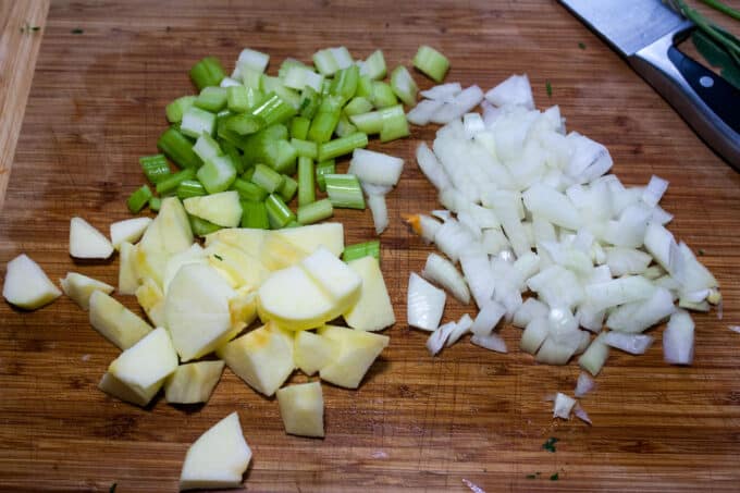 Chopped apple, onion and celery on board.