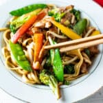 Chopsticks grabbing vegetables from bowl.