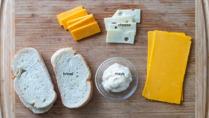 Ingredients for grilled cheese; bread, cheese, mayonnaise.