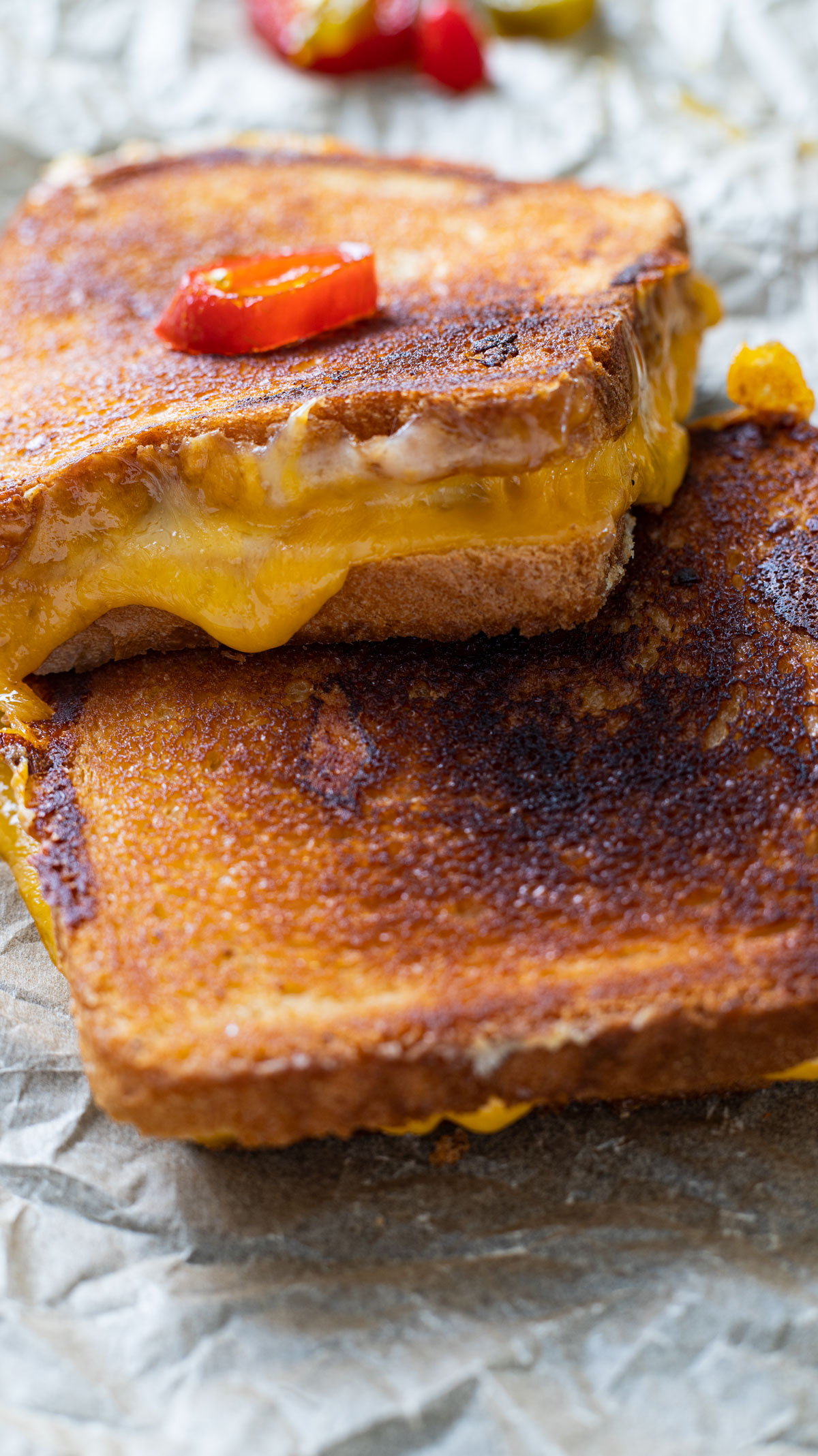 Grilled cheese sandwich on crumpled up waxed paper.