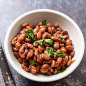 Bowl of whole beans topped with chopped cilantro.
