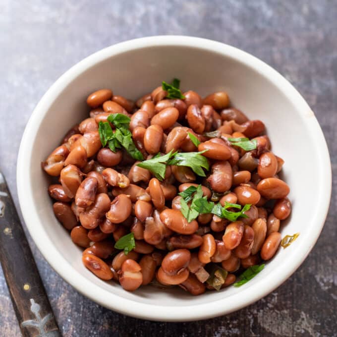 Bowl of whole beans topped with chopped cilantro.