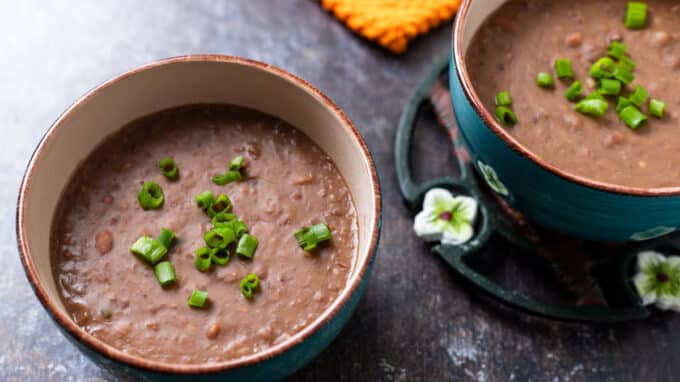 Two green bowls of refried beans.