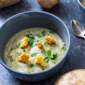 One bowl of potato soup with spoon.