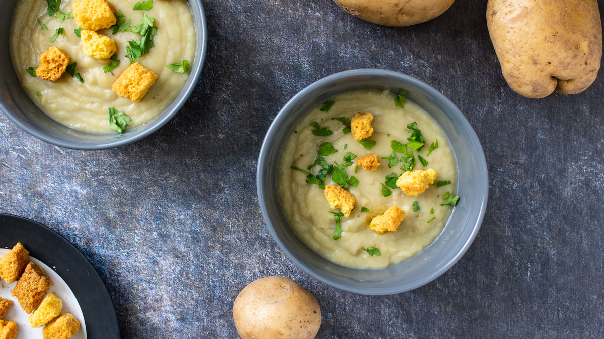 Bowls of soup garnished with fresh parsley and croutons.