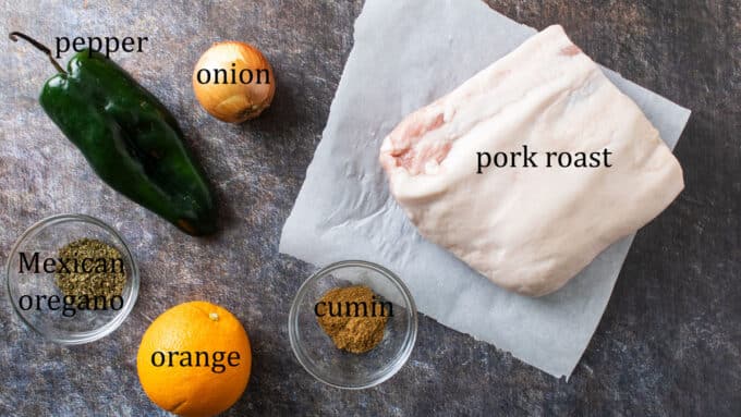 Ingredients for carnitas. Pork, onion, pepper, orange, oregano, cumin.