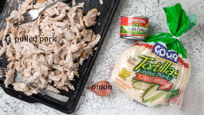 Ingredients for enchiladas. Carnitas, tortillas, green chilies, onion.