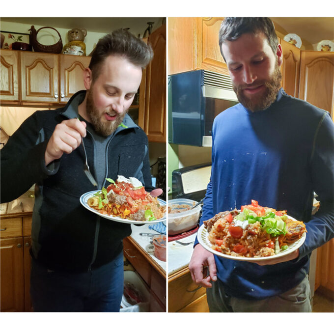 Two men eating pork enchiladas.