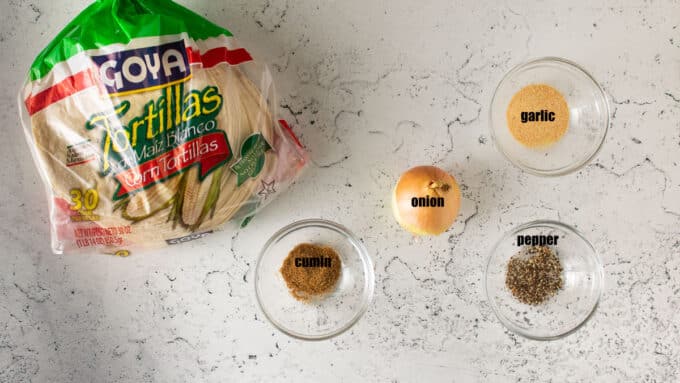 Ingredients for taquitos; tortillas, onion, spices.