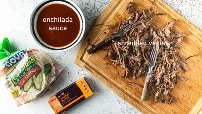 Ingredients to make enchiladas; pulled venison enchilada sauce, tortillas, cheese.