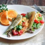 Pork tacos on white plate with all the fixings.