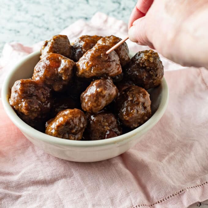 Cranberry orange meatballs in white bowl.