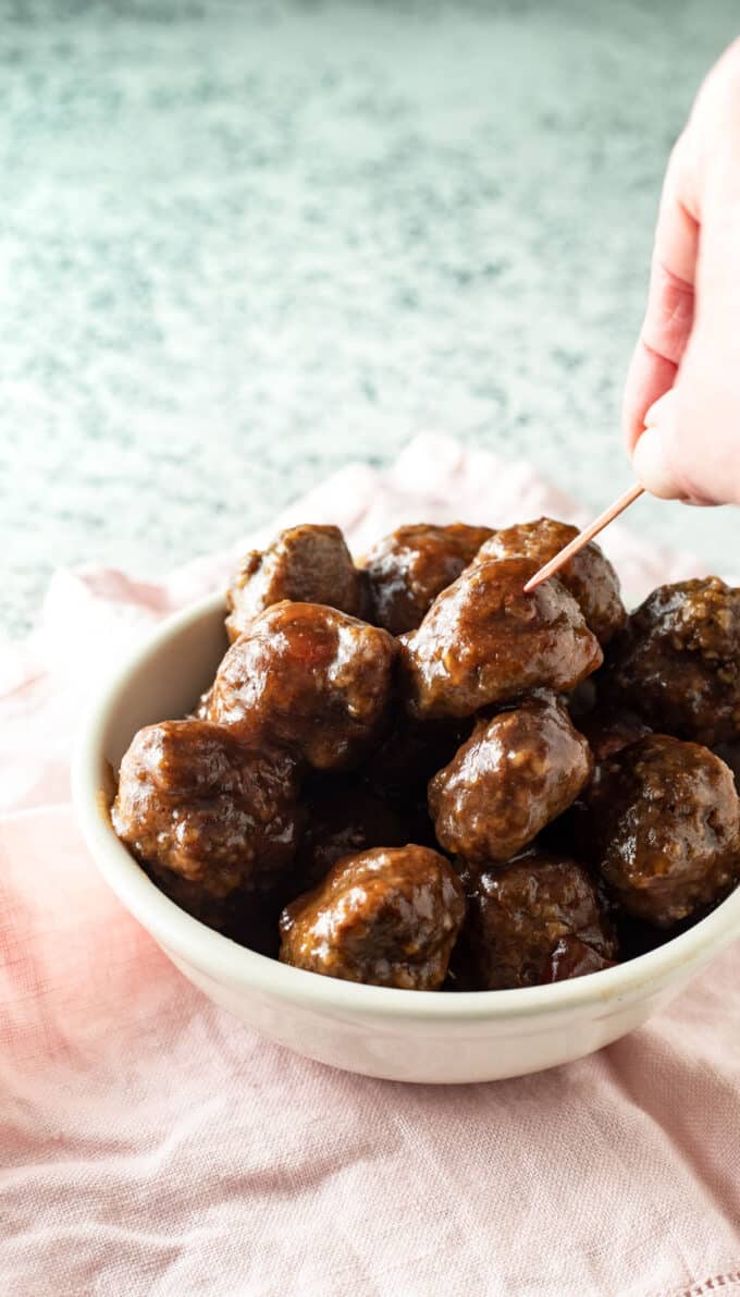 Hand grabbing meatball with toothpick