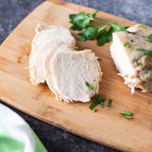 Slices of chicken on wooden board.