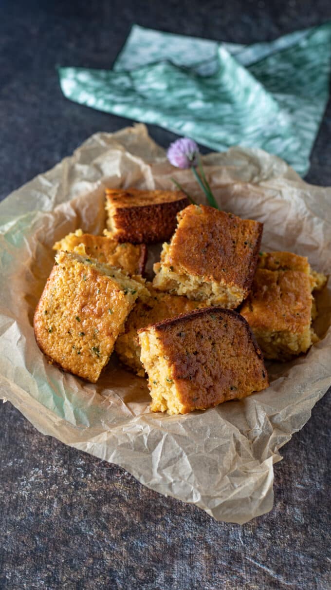 Squares of cornbread piled on parchment.