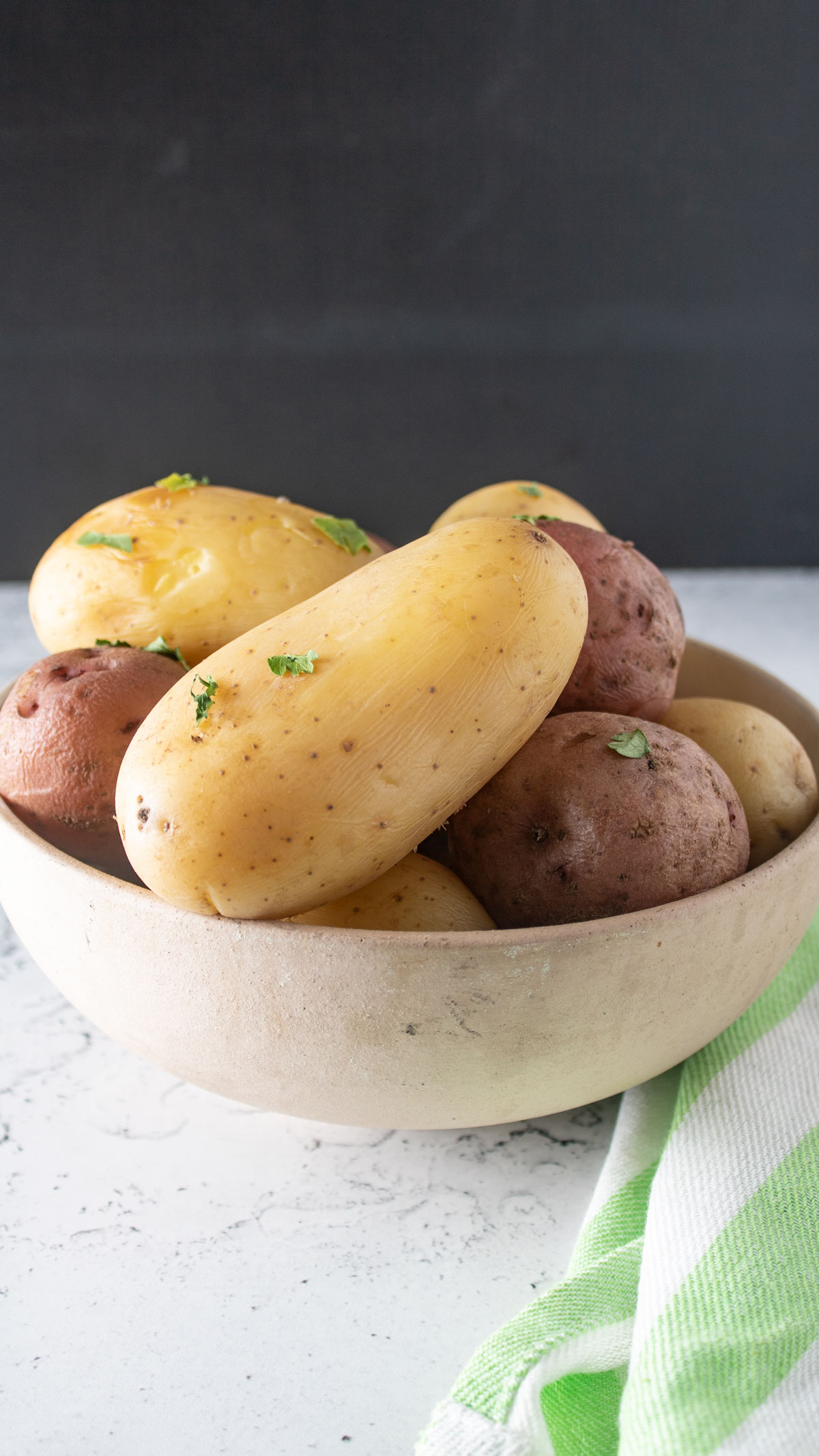Red and white potatoes in beige bowl.