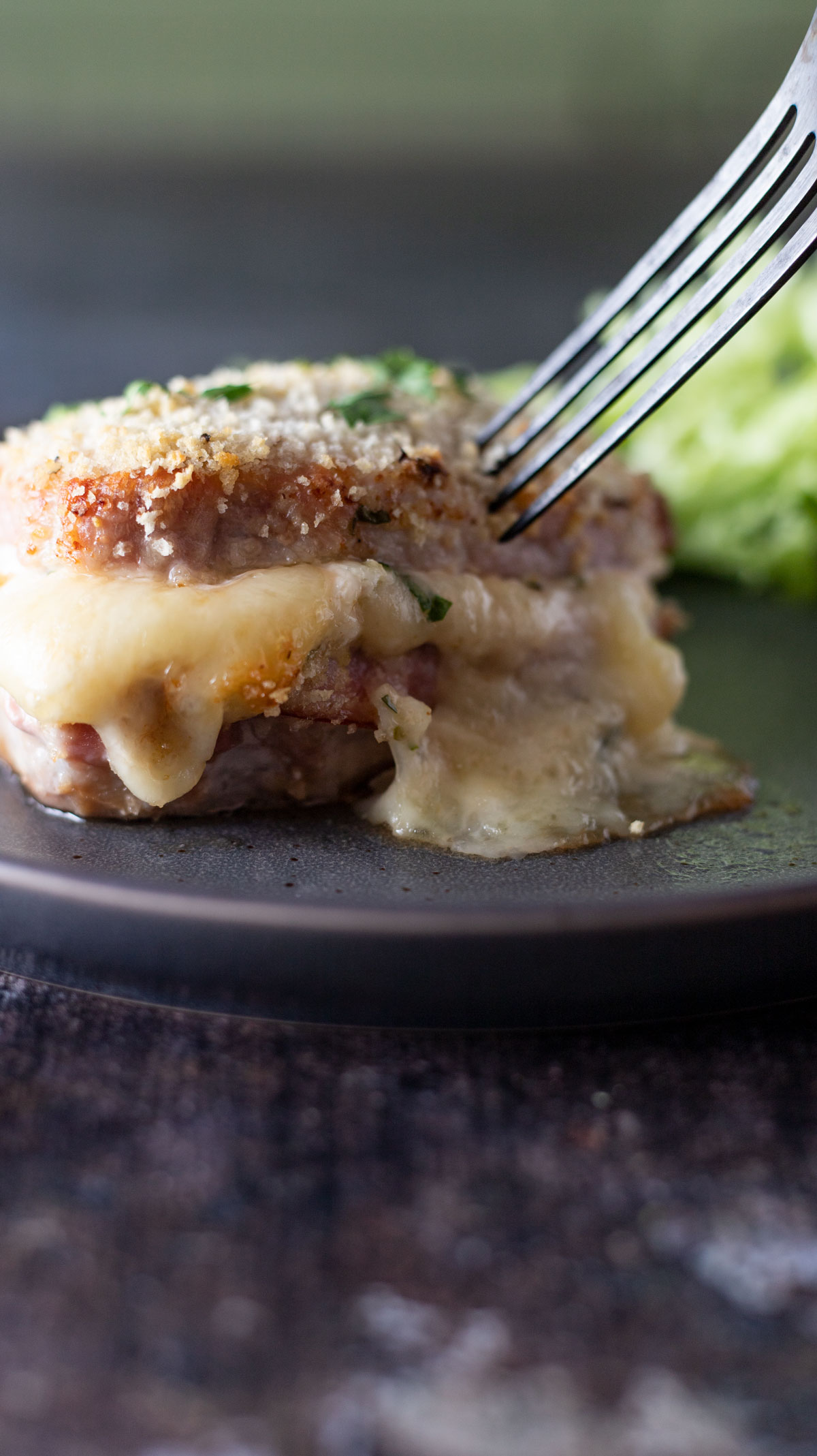 Fork stabbing pork loin chop cordon bleu.