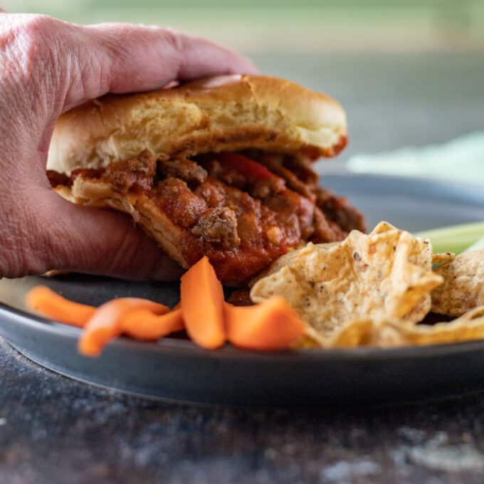 Hand grabbing sloppy joe sandwivh.