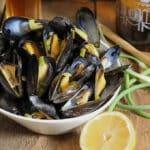 Steamed mussels in a white bowl.