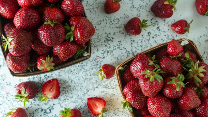 Two quarts of fresh strawberries in antique baskets.