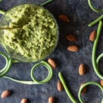 Overhead photo of pesto with almonds and scapes.