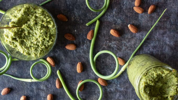 Overhead photo of jar and bowl of pesto with spoon.