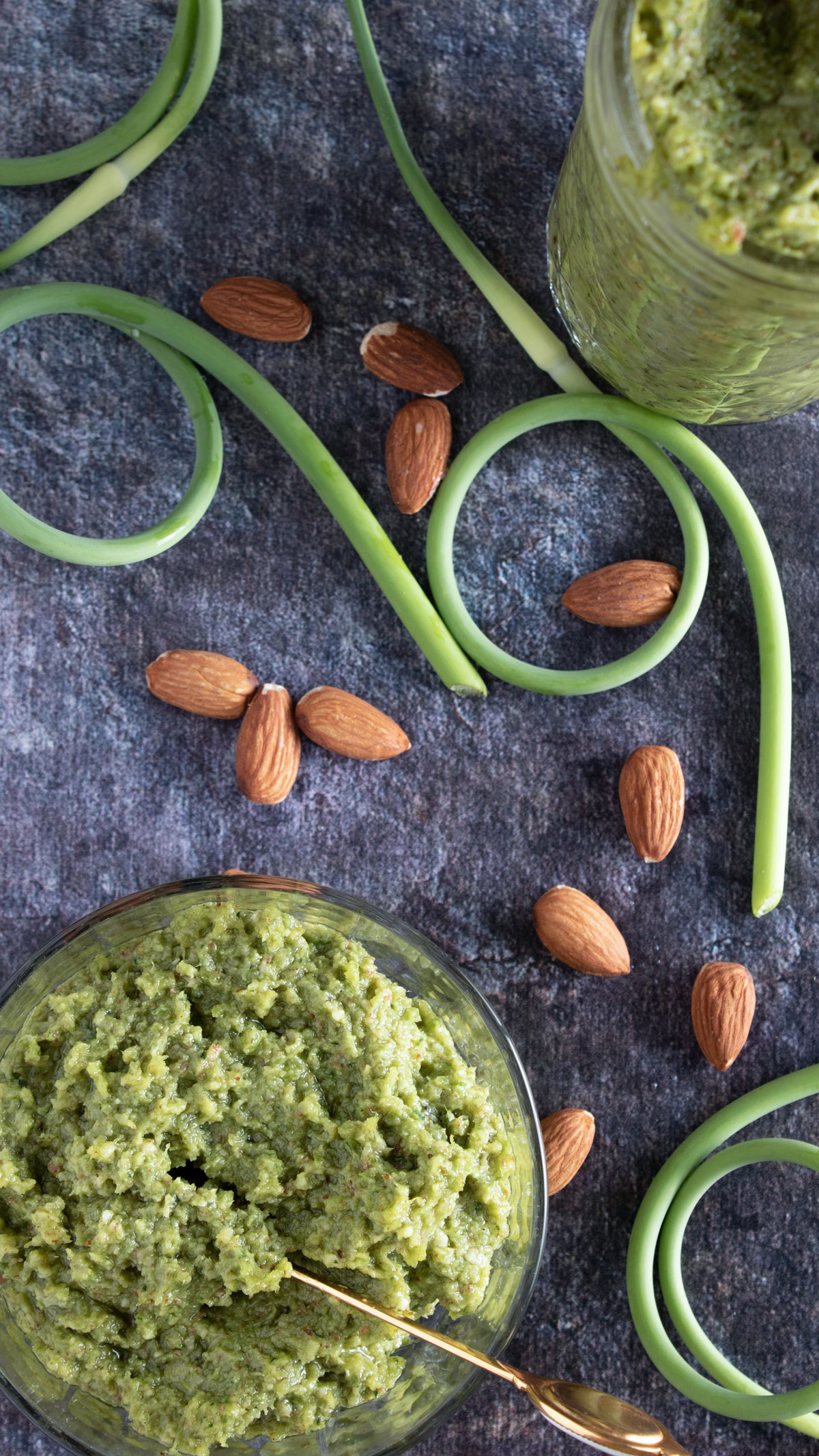 Overhead photo of pesto with almonds and scapes.