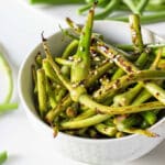 Stir fried garlic scapes in white bowl.
